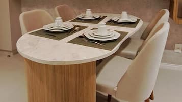 A dining area with a round table, chairs, and a pendant light fixture.