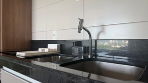 A kitchen with a double sink, a coffee maker, and a laptop on the counter. - Flats no Parque do Cais Recife  (Recife)