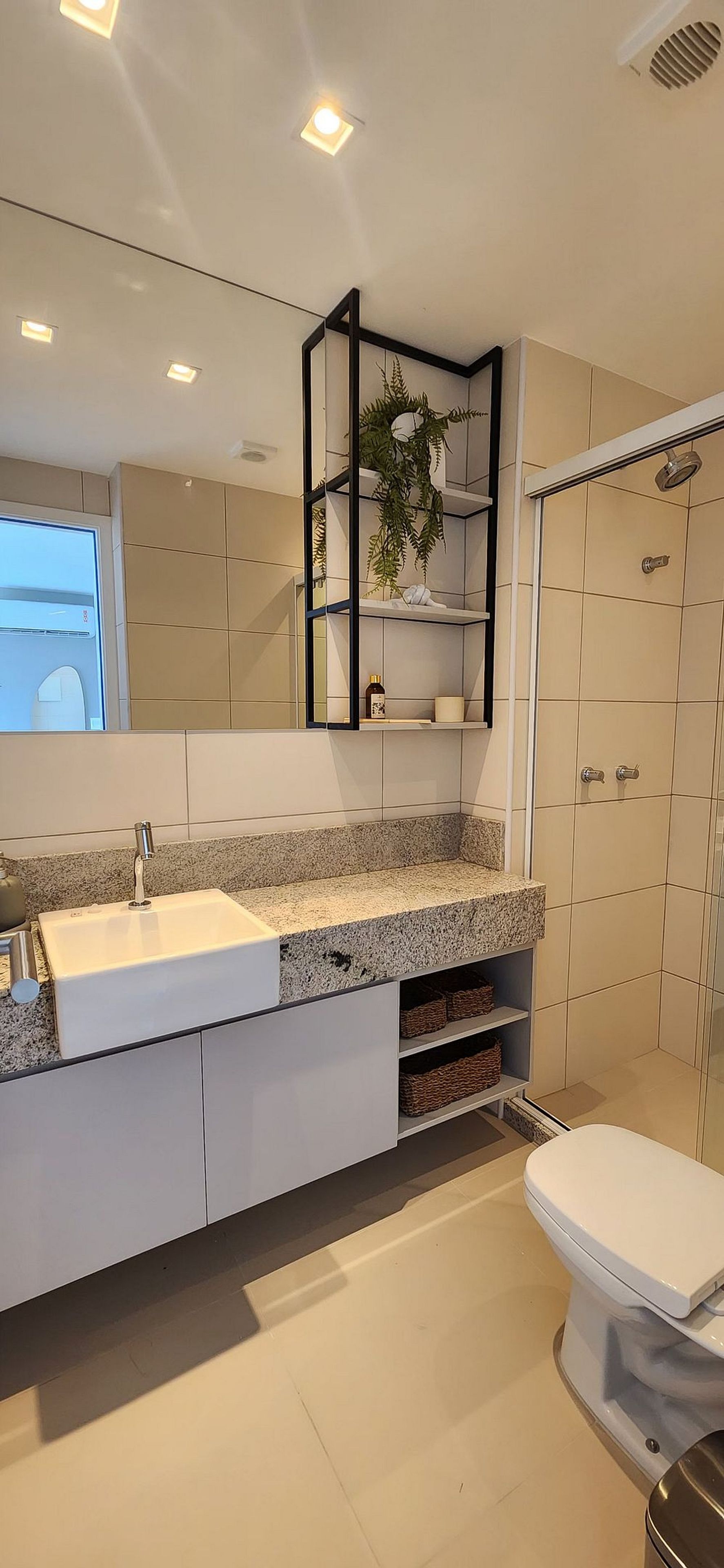 Un baño moderno con un lavabo blanco, un espejo y una ducha.