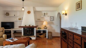 A living room with a fireplace, television, and seating area. - New! Villa Cana Vane (Ibiza)