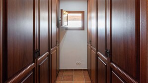 A narrow hallway with wooden doors and a small window at the end. - New! Villa Cana Vane (Ibiza)