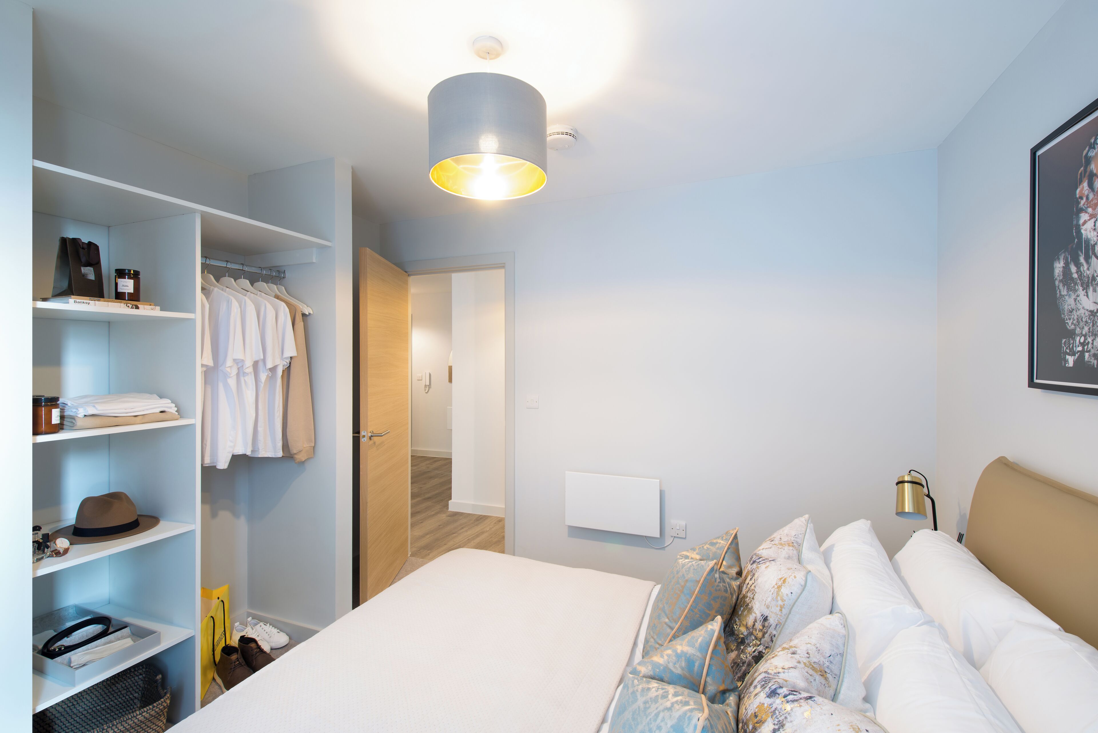 A bedroom with a bed, a wardrobe, and a hallway.