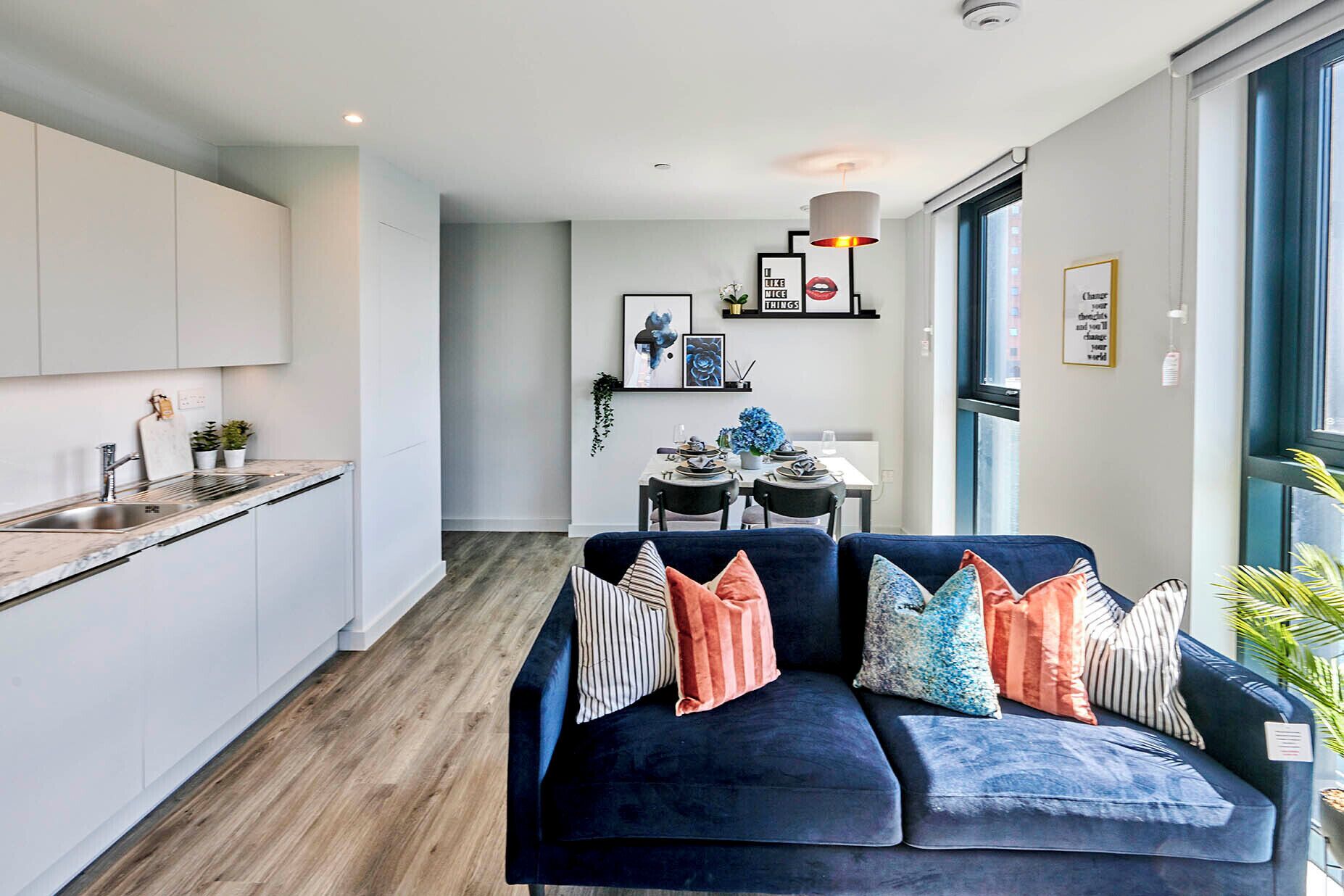 A modern apartment with a kitchen, dining area, and living room.