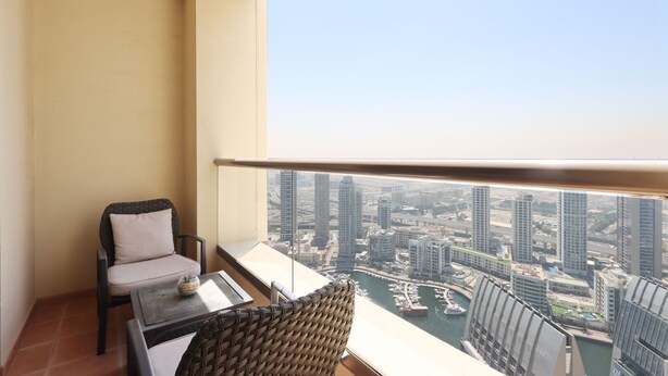 A balcony with a view of a cityscape and a marina. - Livbnb - 2B in Shams Walk to Beach, w/ Marina View (Dubai)