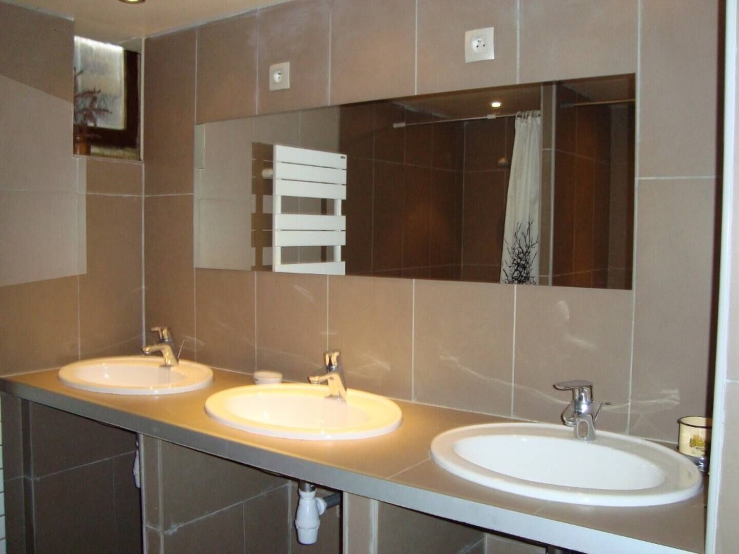 A bathroom with two sinks, a mirror, and a towel rack.