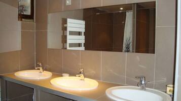 A bathroom with two sinks, a mirror, and a towel rack.