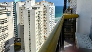 A high-rise building with multiple balconies overlooking a body of water. - Flat Golden Beach (Centro Guarujá)