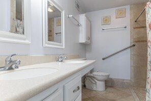 A bathroom with two sinks, a toilet, a shower, and a handrail. - Summer Winds A-512, Oceanfront Condo in Indian Beach, NC! (Indian Beach)