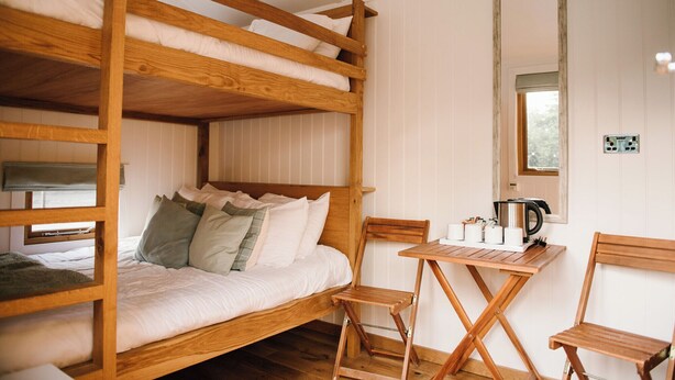 A bunk bed with a desk and chair, a mirror, and a window. - Cosy en suite shepherd hut on the grounds of Historic building Samlesbury Hall (Samlesbury)