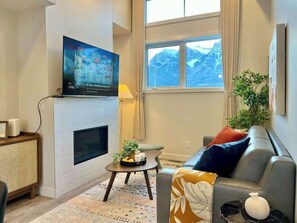 Cozy living room with a fireplace, flat-screen TV, and comfortable seating area.
