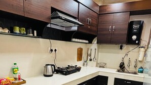 Eine moderne Küche mit dunklen Holzschränken, einer weißen Arbeitsplatte und einer Marmor-Spritzschutzwand.