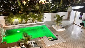 A swimming pool with a green tint, surrounded by potted plants and a tiled deck. - 3-bedroom villa in nice Tenares with AC, WiFi. Enjoy a relaxing stay , Villa J&R (Tenares)