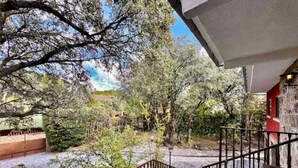 A courtyard with a staircase leading to a covered area, surrounded by trees and a view of a distant landscape. - 7picos-the house in Galapagar. Villa with swimming pool, ideal for family vacations. (Galapagar)