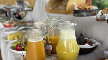 Ein Frühstücksbuffet mit verschiedenen Speisen, darunter Backwaren und ein Krug Orangensaft.