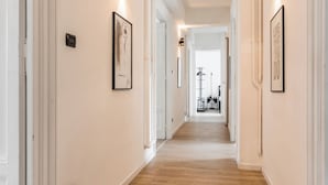 A hallway with wooden flooring, white walls, and framed artwork. - Apartment via Palestrina (Roma)