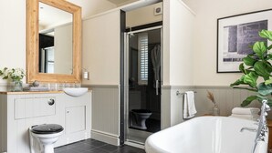 A modern bathroom with a white sink, toilet, and freestanding bathtub. - A beautifully restored Victorian lodge set at the entrance to the picturesque Samlesbury Hall estate (Preston)