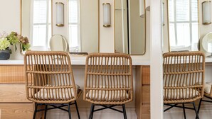 A bathroom with three wicker chairs, a white vanity, and three mirrors with gold frames. - A beautifully restored Victorian lodge set at the entrance to the picturesque Samlesbury Hall estate (Preston)