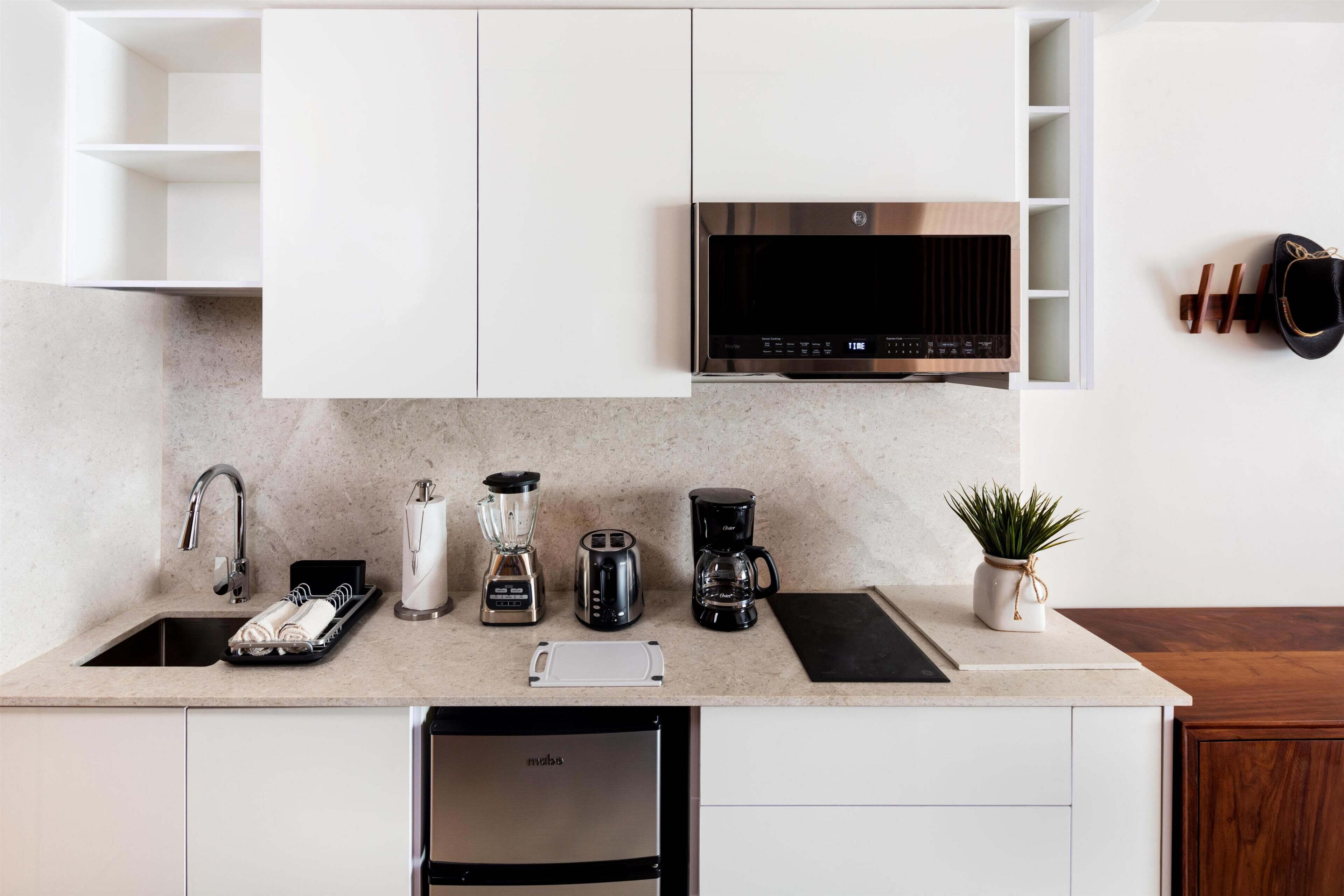 A modern kitchen with a built-in microwave, coffee maker, and toaster.