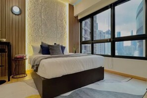 A modern bedroom with a large bed, a city view, and a textured wall. - Agile Residence Bukit Bintang by Heystay Management (Kuala Lumpur)