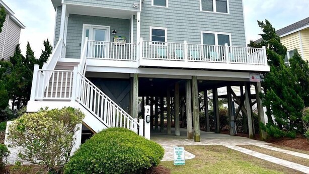 A two-story house with a covered front porch and a balcony.