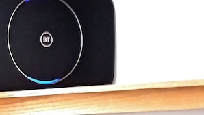 Un appareil électronique noir, orné d’un logo circulaire, posé sur une surface en bois.