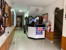 Zona de recepción con mostrador, extintor y cartel con instrucciones de seguridad e higiene.