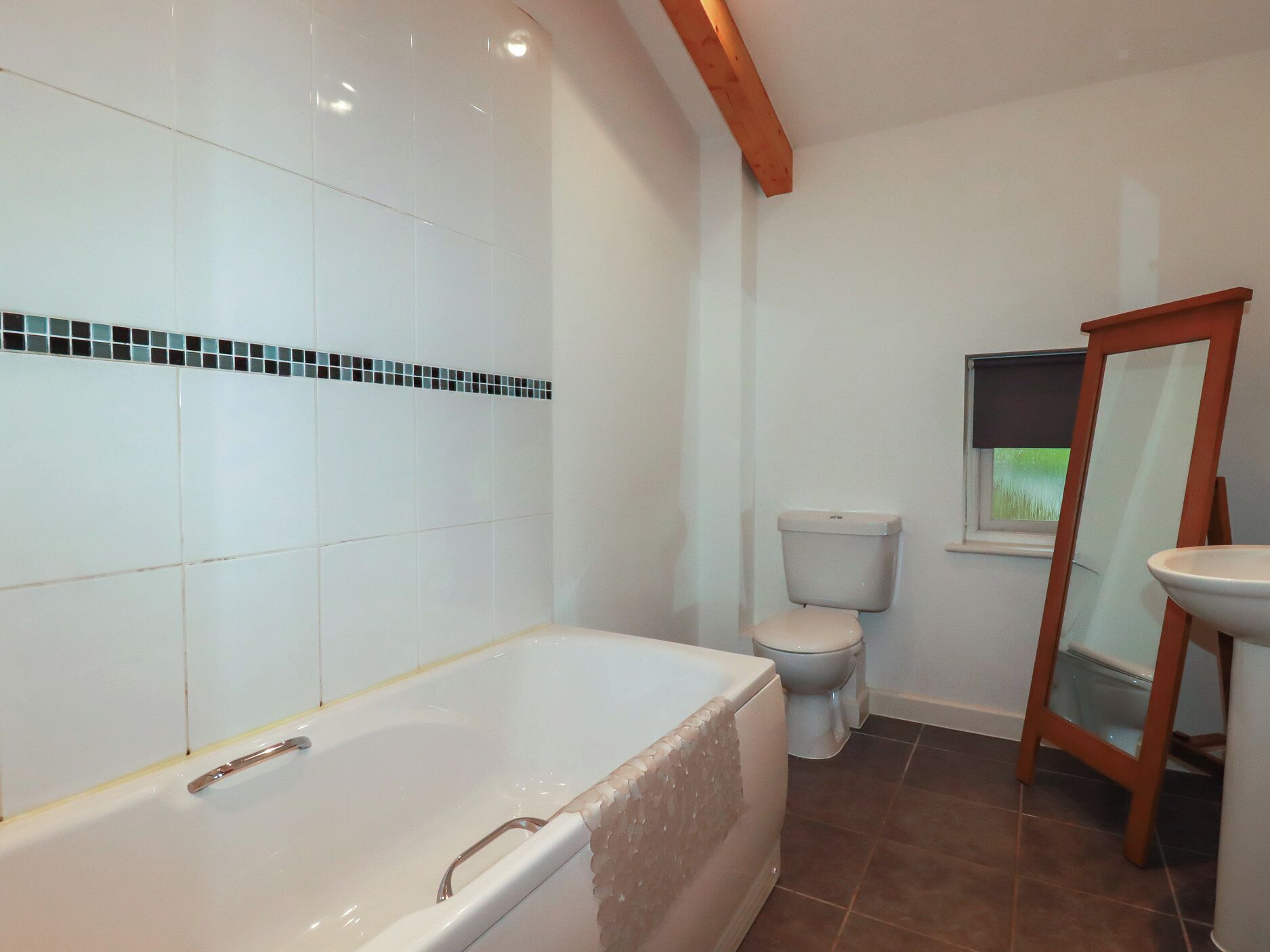 A bathroom with a bathtub, toilet, and sink.