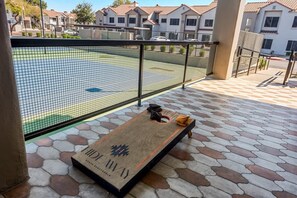 A courtyard with a badminton net, a wooden bench, and a view of residential buildings. - Sleek 2BR-Pool, BBQ, Prkng, Yoga Rm, Gym, Cabanas (Scottsdale)