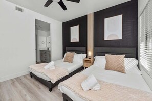 A modern bedroom with two beds, a nightstand, and a mirror. - Sleek 2BR-Pool, BBQ, Prkng, Yoga Rm, Gym, Cabanas (Scottsdale)