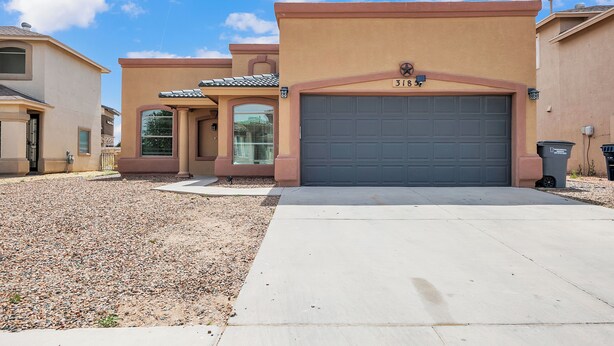 A residential building with a garage number 318, a driveway, and a gravel area.