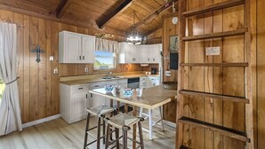 Una cocina rústica con paredes de madera y una isla central con taburetes.