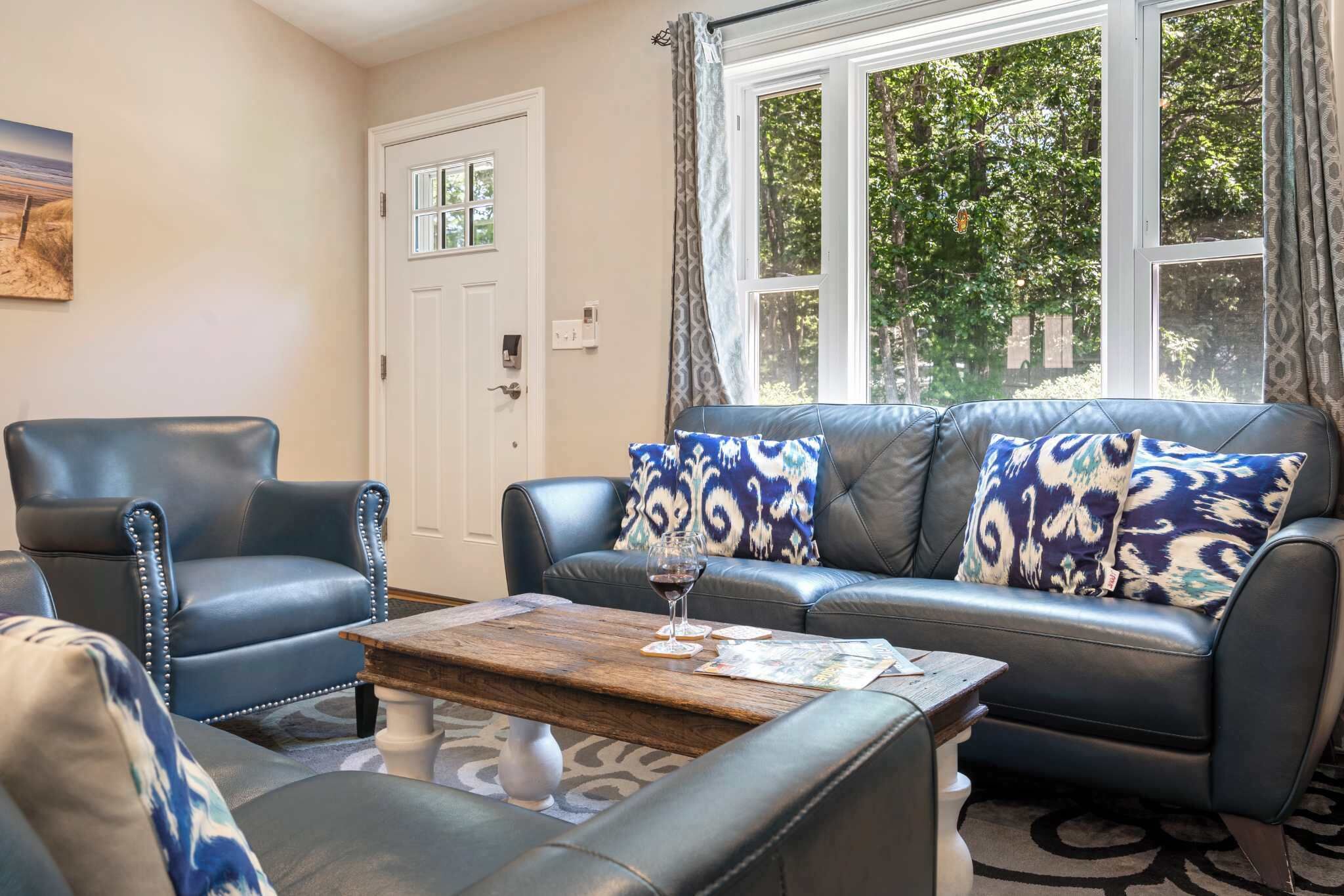 A living room with a leather sofa, a matching armchair, and a coffee table.