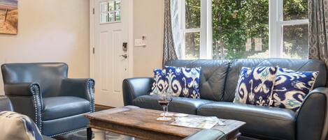 A living room with a leather sofa, a matching armchair, and a coffee table.
