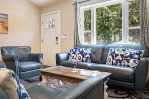A living room with a leather sofa, a matching armchair, and a coffee table. - Single Level 4BR Pet-Friendly Home (Kennebunkport)