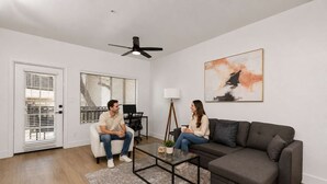 A modern living room with a sofa, coffee table, and a ceiling fan.