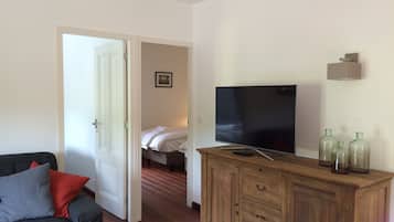 A room with a wooden cabinet, a television, and a bed.