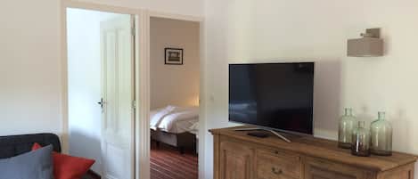 Huoneessa on puinen kaappi, televisio ja sänky.