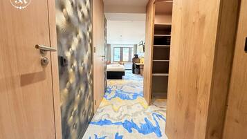 A hotel room with a bed, a desk, and a wardrobe.