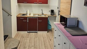 A compact kitchen with a microwave, sink, and red cabinets. - Central apartment 70 m² up to 4 persons - close to the main station & trade fair Essen (Essen)