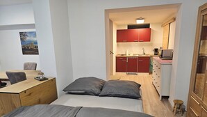 A compact bedroom with a bed, a desk, and a kitchenette. - Central apartment 70 m² up to 4 persons - close to the main station & trade fair Essen (Essen)