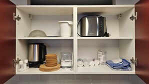 A kitchen with a built-in microwave, coffee maker, and a coffee pot. - Central apartment 70 m² up to 4 persons - close to the main station & trade fair Essen (Essen)