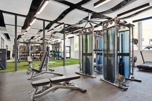 A gym with various exercise equipment, including weight machines and free weights.