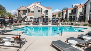 A pool area with lounge chairs and a building with a tiled roof. - Modern2BR Pickle&Basketball Ct,Pool,BBQ Cabanas (Scottsdale)