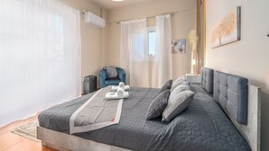 A modern bedroom with a large bed, a chair, and a nightstand. - Casa Antigone - Comfortable house in Athens Metro Mall (Athens)