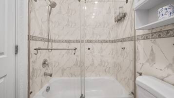 A bathroom with a shower enclosure, a bathtub, and a toilet.