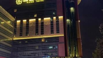 A hotel building with illuminated signage and a prominent vertical structure.