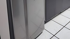 Eine moderne Küche mit einem Edelstahl-Kühlschrank, einem Backofen und einer Mikrowelle.