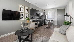 Un appartement moderne comprenant une cuisine, un coin repas et un salon.