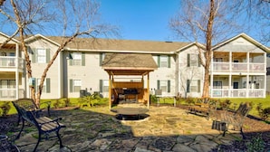 A courtyard with stone flooring, outdoor seating, and a covered area with a fire pit. - Beach short drive - Pool - Hot Tub K/Q, 2 BA, Sleeps 4 in beds- Ground Floor (Gulf Shores)