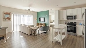 Een modern appartement met een woonkamer, eetgedeelte en keuken.